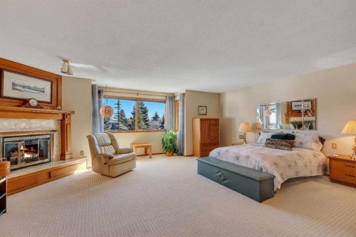 223 Shawnee Mews Sw, Calgary, AB - Indoor Photo Showing Bedroom With Fireplace