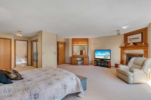 223 Shawnee Mews Sw, Calgary, AB - Indoor Photo Showing Bedroom With Fireplace