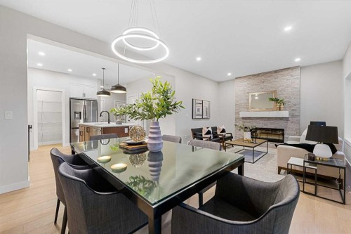 128 Versant Point Sw, Calgary, AB - Indoor Photo Showing Dining Room With Fireplace