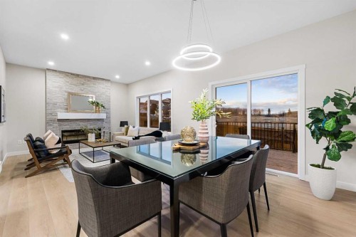 128 Versant Point Sw, Calgary, AB - Indoor Photo Showing Dining Room With Fireplace