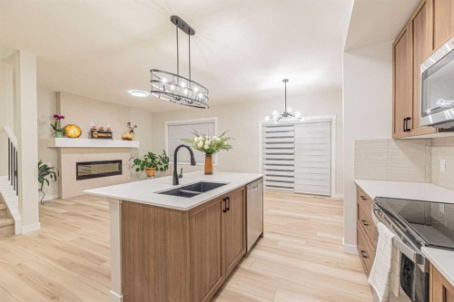 65 Amblefield View Nw, Calgary, AB - Indoor Photo Showing Kitchen With Fireplace With Double Sink