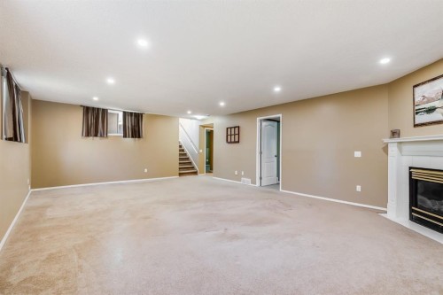 1808 Meadowbrook Gate Se, Airdrie, AB - Indoor Photo Showing Basement With Fireplace