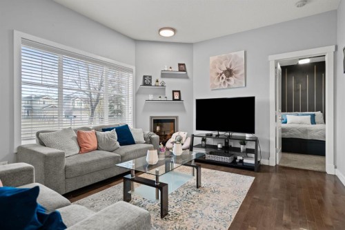 301-281 Cougar Ridge Drive Sw, Calgary, AB - Indoor Photo Showing Living Room With Fireplace