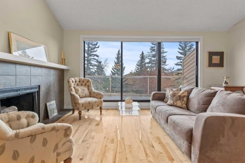 6-1220 Prominence Way Sw, Calgary, AB - Indoor Photo Showing Living Room With Fireplace