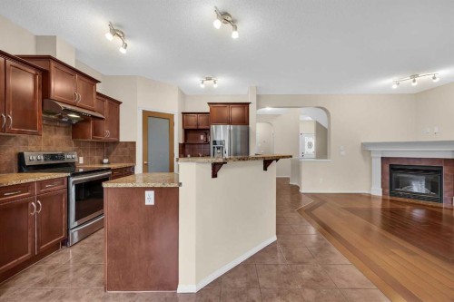 109 Bridlerange Place Sw, Calgary, AB - Indoor Photo Showing Kitchen With Fireplace