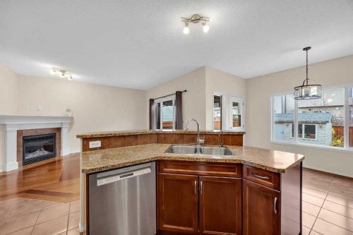 109 Bridlerange Place Sw, Calgary, AB - Indoor Photo Showing Kitchen With Fireplace With Double Sink