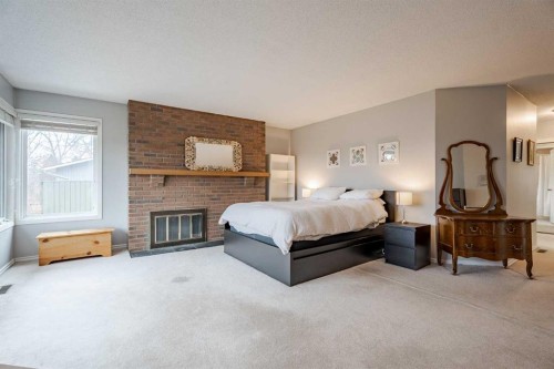 2427 Deer Side Drive, Calgary, AB - Indoor Photo Showing Bedroom With Fireplace