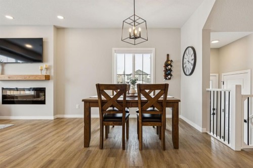 103 Saddlebred Link, Cochrane, AB - Indoor Photo Showing Dining Room With Fireplace