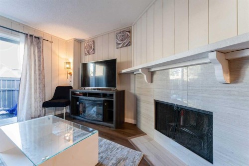 1101-829 Coach Bluff Crescent Sw, Calgary, AB - Indoor Photo Showing Living Room With Fireplace