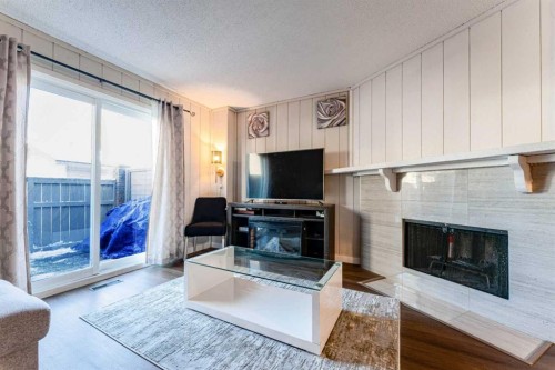 1101-829 Coach Bluff Crescent Sw, Calgary, AB - Indoor Photo Showing Living Room With Fireplace