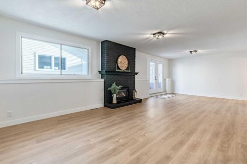 15 Woodford Crescent Sw, Calgary, AB - Indoor Photo Showing Other Room With Fireplace
