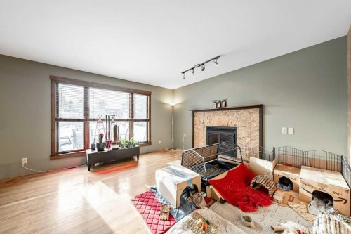 15 Strathlorne Bay Sw, Calgary, AB - Indoor Photo Showing Living Room With Fireplace
