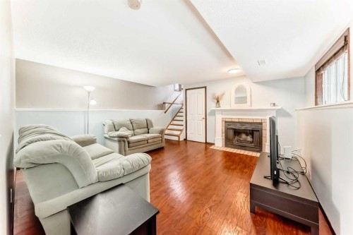219 Sandstone Drive Nw, Calgary, AB - Indoor Photo Showing Living Room With Fireplace