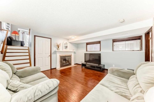 219 Sandstone Drive Nw, Calgary, AB - Indoor Photo Showing Living Room With Fireplace