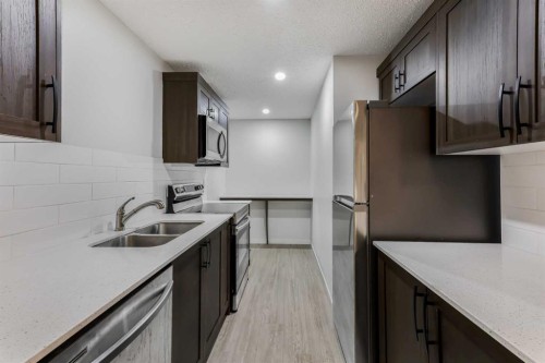 15 Edith Passage Nw, Calgary, AB - Indoor Photo Showing Kitchen With Double Sink