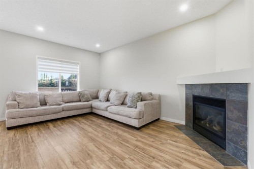 64 Cougarstone Square Sw, Calgary, AB - Indoor Photo Showing Living Room With Fireplace