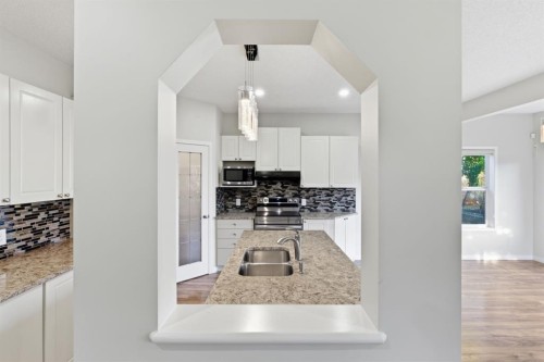 64 Cougarstone Square Sw, Calgary, AB - Indoor Photo Showing Kitchen With Double Sink