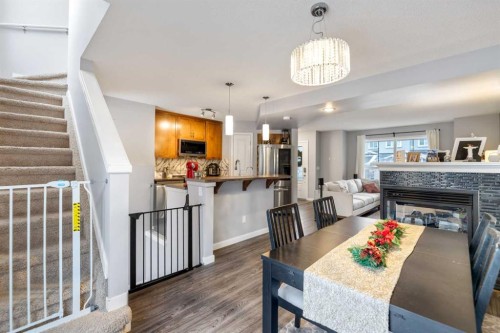 243 New Brighton Landing Se, Calgary, AB - Indoor Photo Showing Dining Room With Fireplace