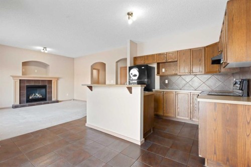 1083 Prairie Springs Hill Sw, Airdrie, AB - Indoor Photo Showing Kitchen With Fireplace