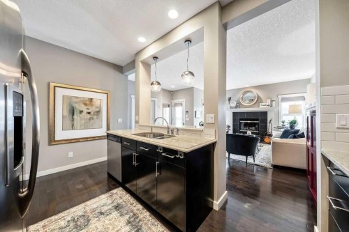 78 Ypres Green Sw, Calgary, AB - Indoor Photo Showing Kitchen With Fireplace With Double Sink With Upgraded Kitchen