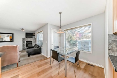 307 Panatella Court Nw, Calgary, AB - Indoor Photo Showing Dining Room With Fireplace