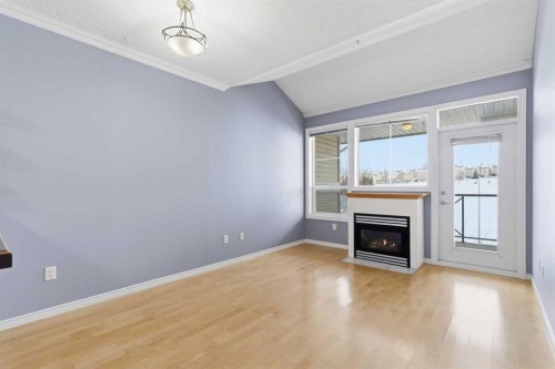 1302-1010 Arbour Lake Road Nw, Calgary, AB - Indoor Photo Showing Living Room With Fireplace