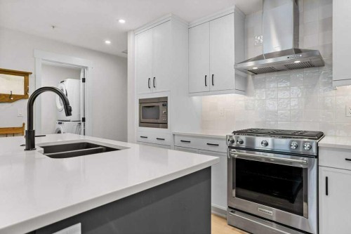 107-1315 Spring Creek Gate, Canmore, AB - Indoor Photo Showing Kitchen With Stainless Steel Kitchen With Double Sink With Upgraded Kitchen