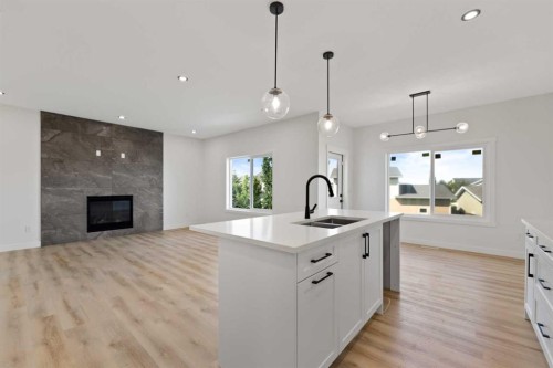 9 Mcclung Gate, Carstairs, AB - Indoor Photo Showing Kitchen With Fireplace With Double Sink With Upgraded Kitchen