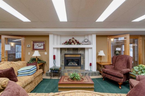 211-728 Country Hills Road Nw, Calgary, AB - Indoor Photo Showing Living Room With Fireplace