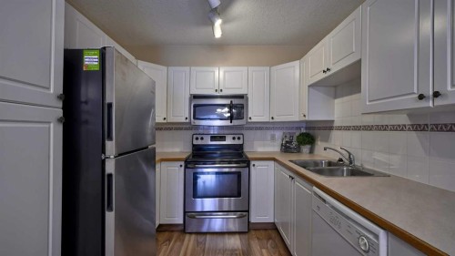 211-728 Country Hills Road Nw, Calgary, AB - Indoor Photo Showing Kitchen With Stainless Steel Kitchen With Double Sink