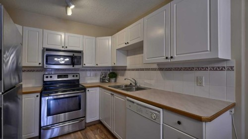 211-728 Country Hills Road Nw, Calgary, AB - Indoor Photo Showing Kitchen With Stainless Steel Kitchen With Double Sink