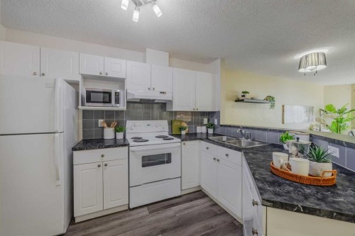 1311-950 Arbour Lake Road Nw, Calgary, AB - Indoor Photo Showing Kitchen With Double Sink