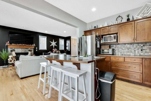 155 Cimarron Grove Circle, Okotoks, AB - Indoor Photo Showing Kitchen With Fireplace