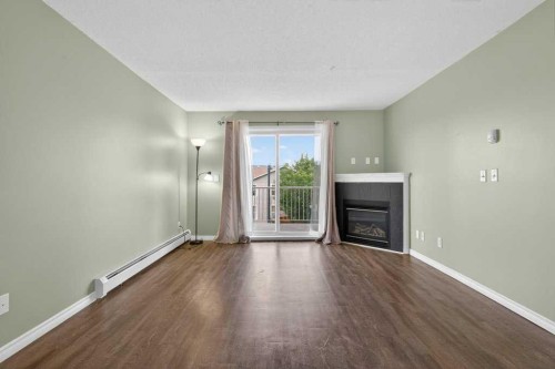 4316-10 Prestwick Bay Se, Calgary, AB - Indoor Photo Showing Living Room With Fireplace