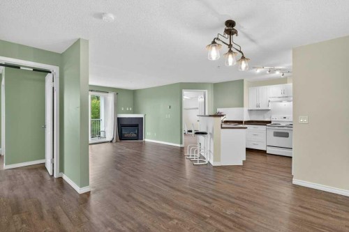 4316-10 Prestwick Bay Se, Calgary, AB - Indoor Photo Showing Kitchen With Fireplace