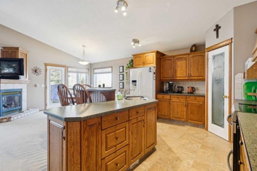 123 Whispering Way, Vulcan, AB - Indoor Photo Showing Kitchen With Fireplace