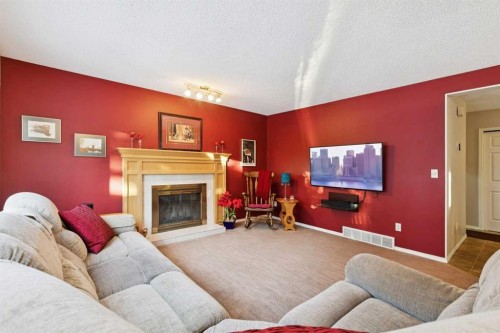 201-132 Straddock Crescent Sw, Calgary, AB - Indoor Photo Showing Living Room With Fireplace