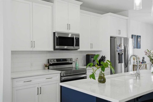 496 Reynolds Avenue Sw, Airdrie, AB - Indoor Photo Showing Kitchen With Stainless Steel Kitchen With Upgraded Kitchen