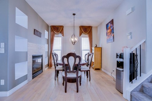 77 Saddleland Drive Ne, Calgary, AB - Indoor Photo Showing Dining Room With Fireplace