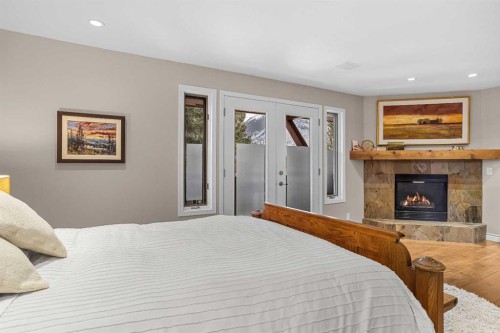 12 Antelope Lane, Banff, AB - Indoor Photo Showing Bedroom With Fireplace
