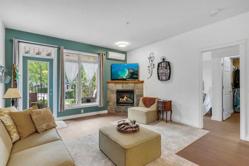 101-8 Hemlock Crescent Sw, Calgary, AB - Indoor Photo Showing Living Room With Fireplace