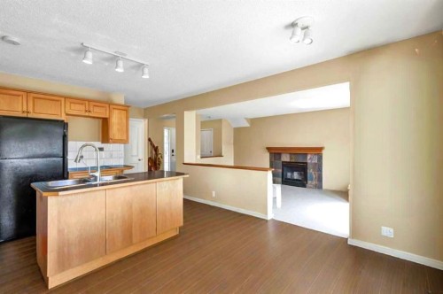 11137 Hidden Valley Drive Nw, Calgary, AB - Indoor Photo Showing Kitchen With Fireplace With Double Sink