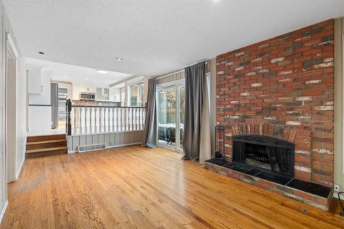 1447 Acadia Drive Se, Calgary, AB - Indoor Photo Showing Living Room With Fireplace