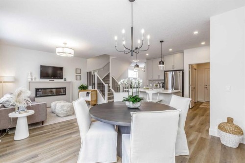 546 Rivercrest View, Cochrane, AB - Indoor Photo Showing Dining Room With Fireplace