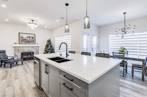714 Mandalay Link, Carstairs, AB - Indoor Photo Showing Kitchen With Fireplace With Double Sink