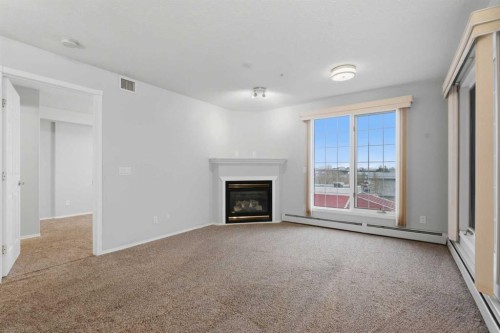 358-8535 Bonaventure Drive Se, Calgary, AB - Indoor Photo Showing Living Room With Fireplace