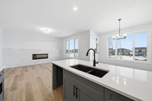 301 Dawson Wharf Road, Chestermere, AB - Indoor Photo Showing Kitchen With Fireplace With Double Sink