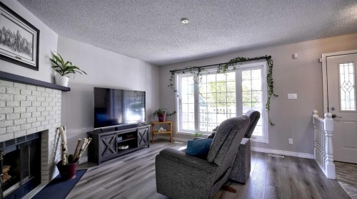 78 Athabasca Crescent, Crossfield, AB - Indoor Photo Showing Living Room With Fireplace