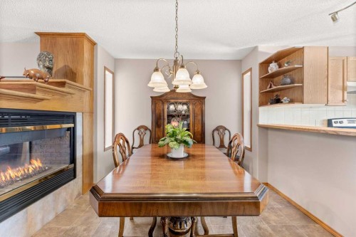 164 Stonegate Close Nw, Airdrie, AB - Indoor Photo Showing Dining Room With Fireplace