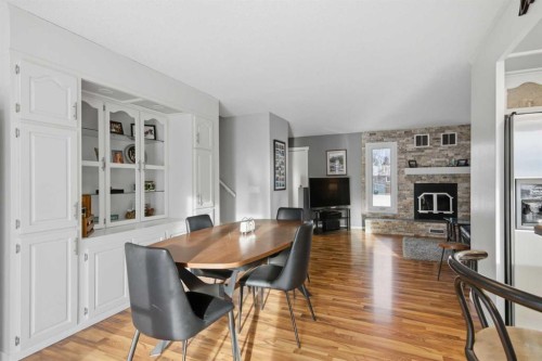 127 Queen Tamara Road Se, Calgary, AB - Indoor Photo Showing Dining Room With Fireplace